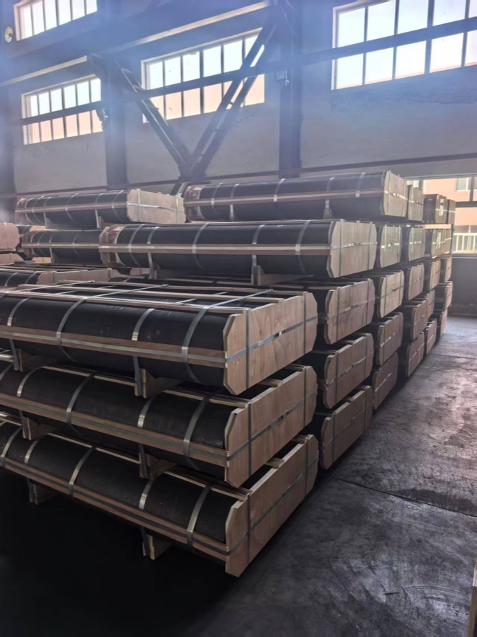 Packed graphite electrodes in wood-framed supports inside the Yulinde warehouse